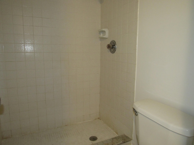 bathroom featuring toilet and tiled shower