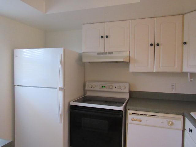 kitchen with custom range hood, white appliances, and white cabinetry