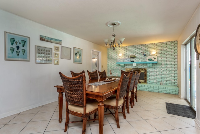 tiled dining area featuring brick wall and a chandelier