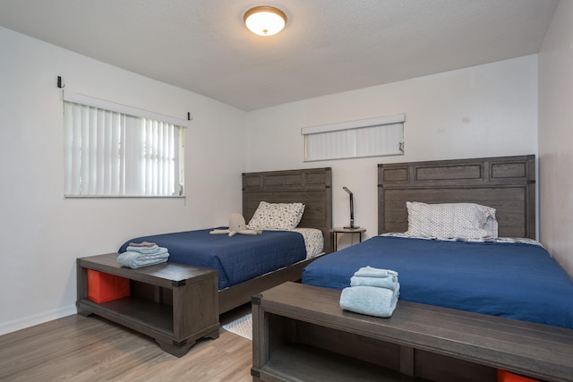 bedroom with light hardwood / wood-style floors and a textured ceiling