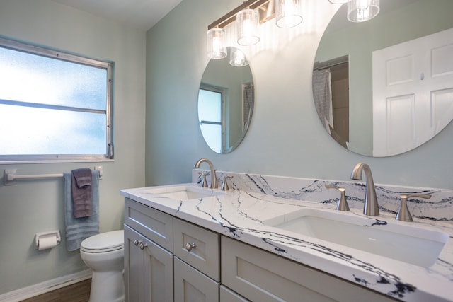 bathroom with a healthy amount of sunlight, toilet, and vanity