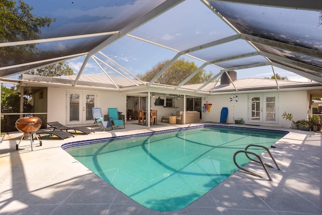 view of swimming pool featuring a patio, a lanai, and french doors