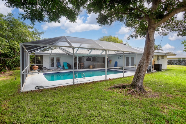 view of pool with french doors, a lawn, glass enclosure, and central air condition unit