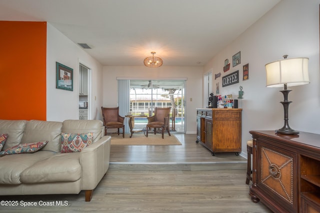 living room with an inviting chandelier and light hardwood / wood-style flooring