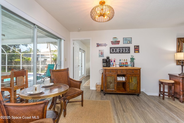 dining room with hardwood / wood-style floors and a textured ceiling