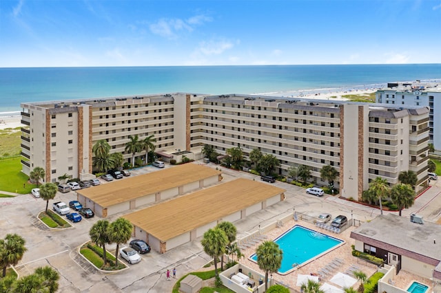 drone / aerial view with a water view and a beach view