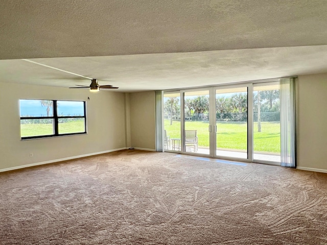 carpeted spare room featuring ceiling fan and a textured ceiling