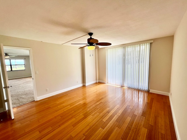 spare room with ceiling fan and light colored carpet