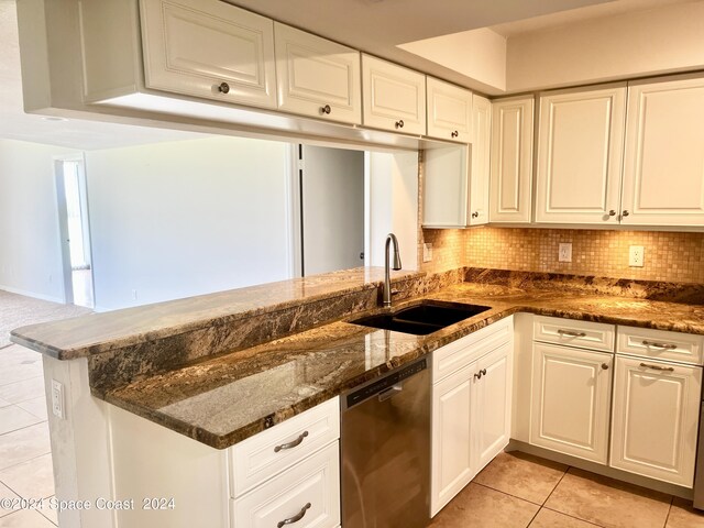 kitchen featuring a sink, white cabinetry, dark stone counters, and dishwasher