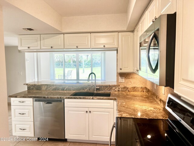 kitchen featuring visible vents, stainless steel appliances, a sink, and white cabinetry