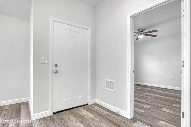 entryway with a ceiling fan, wood finished floors, visible vents, and baseboards