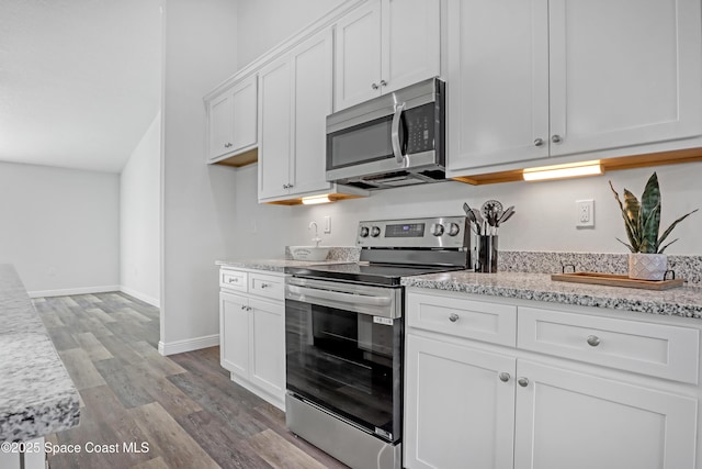 kitchen featuring light stone counters, stainless steel appliances, baseboards, light wood-style floors, and white cabinets