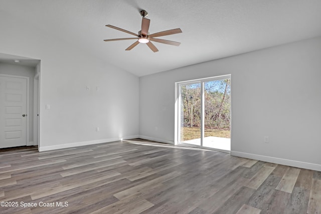 unfurnished room featuring vaulted ceiling, ceiling fan, wood finished floors, and baseboards