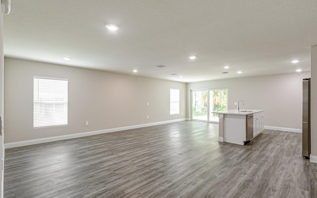 unfurnished living room with sink and light hardwood / wood-style floors