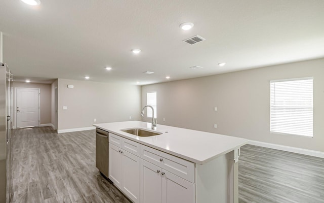 kitchen featuring sink, white cabinetry, a center island with sink, light hardwood / wood-style flooring, and stainless steel dishwasher