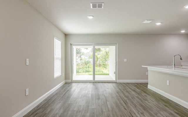 unfurnished living room with sink and dark wood-type flooring