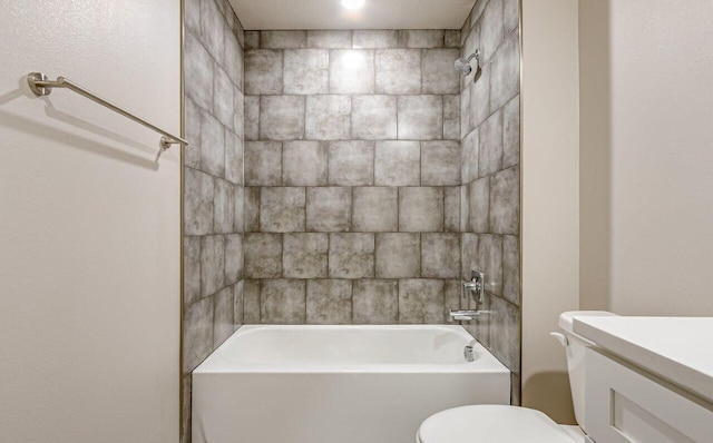 full bathroom featuring vanity, tiled shower / bath, and toilet