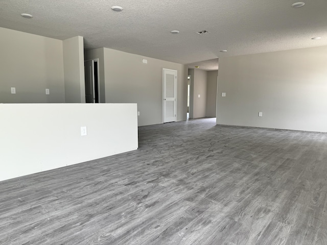 spare room with light hardwood / wood-style floors and a textured ceiling