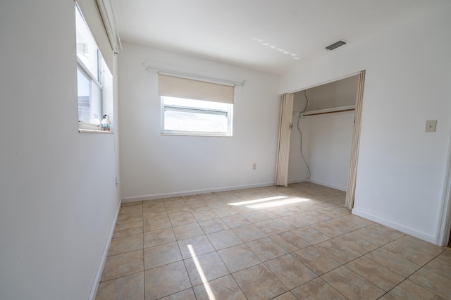 unfurnished bedroom featuring light tile patterned flooring and a closet