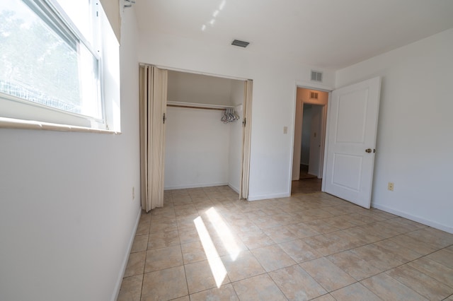 unfurnished bedroom with a closet and light tile patterned floors