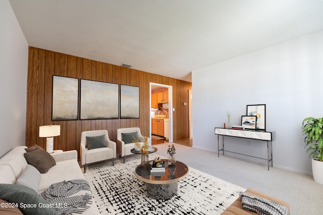 living room featuring light carpet and wooden walls