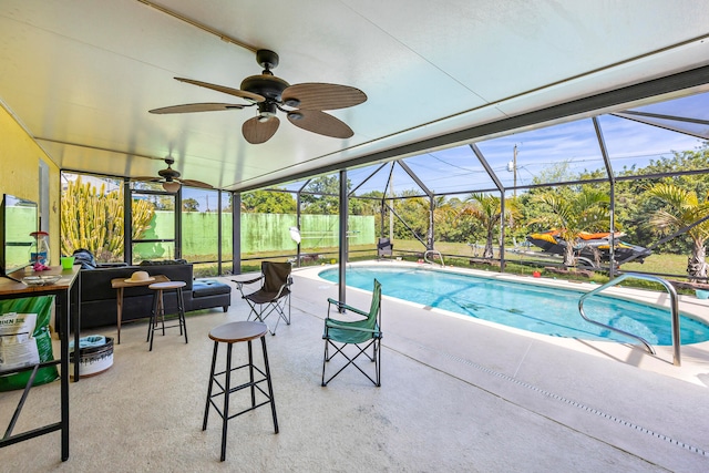 view of pool with glass enclosure, ceiling fan, and a patio