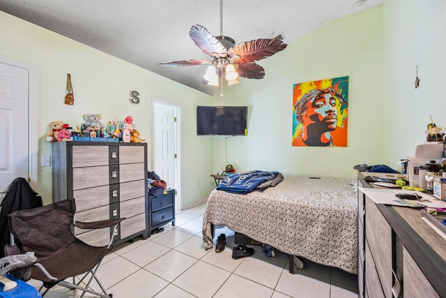 bedroom with a textured ceiling, ceiling fan, and light tile floors