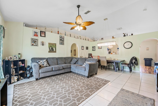 tiled living room with lofted ceiling and ceiling fan