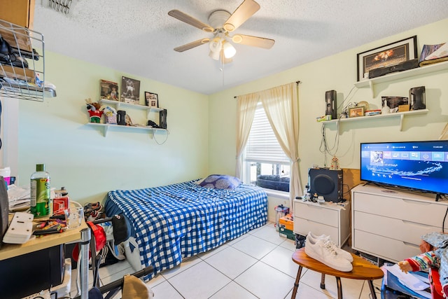 tiled bedroom featuring ceiling fan and a textured ceiling