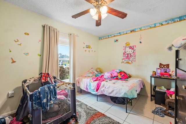 bedroom featuring light tile floors, ceiling fan, and a textured ceiling