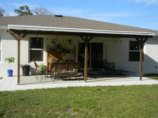 back of property with a lawn and a patio