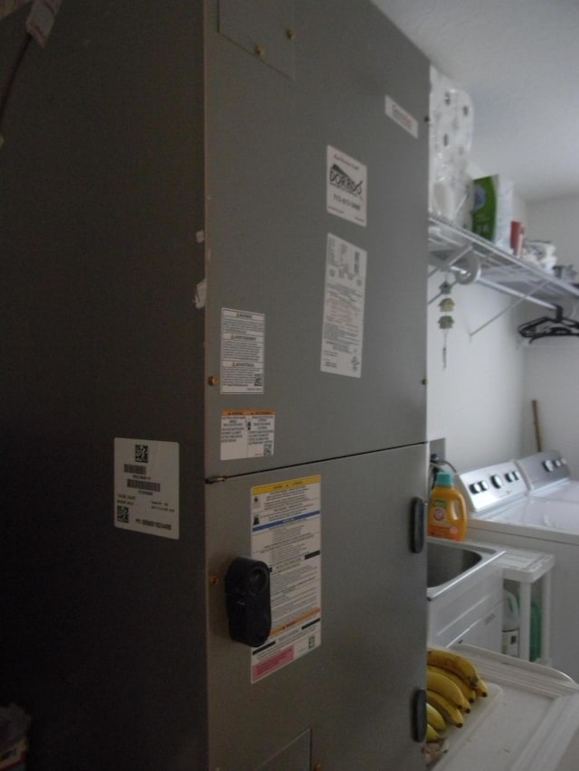 utility room with washer and clothes dryer and heating utilities