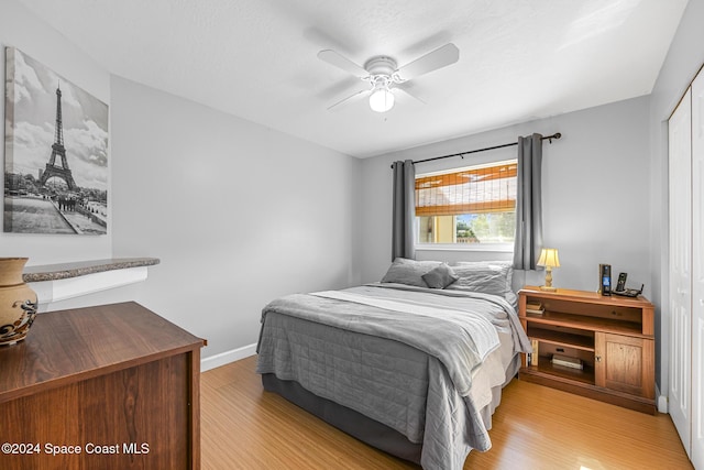 bedroom featuring ceiling fan, a closet, and light wood-type flooring