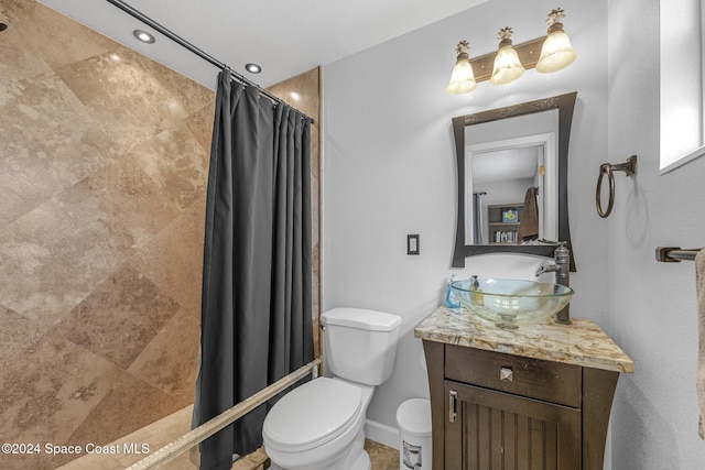 bathroom with vanity, a textured ceiling, and toilet