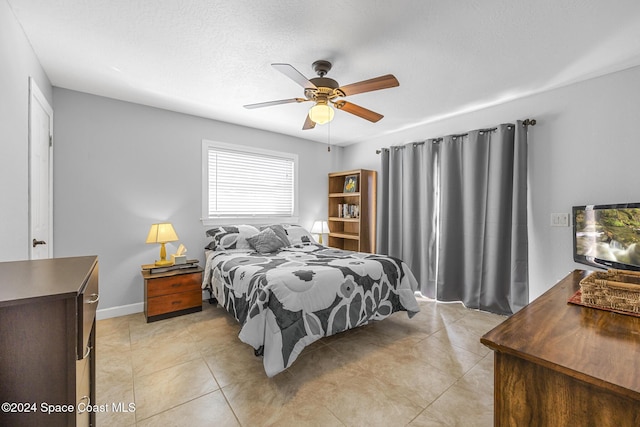 bedroom with a textured ceiling, ceiling fan, and light tile patterned flooring