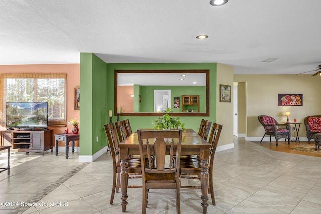 dining room featuring ceiling fan, light tile patterned floors, and a textured ceiling