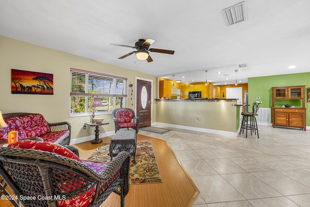 living room featuring light tile patterned floors and ceiling fan