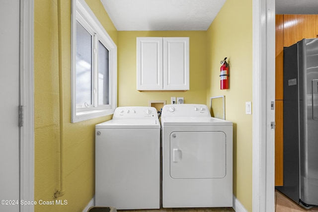 washroom featuring cabinets and independent washer and dryer