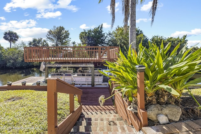 wooden deck with a water view and a boat dock