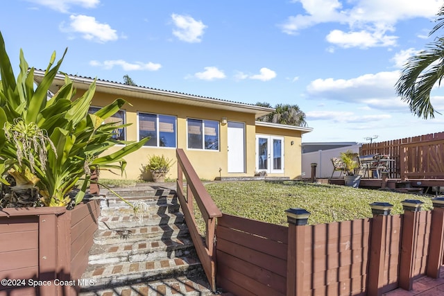 rear view of property with a wooden deck and french doors