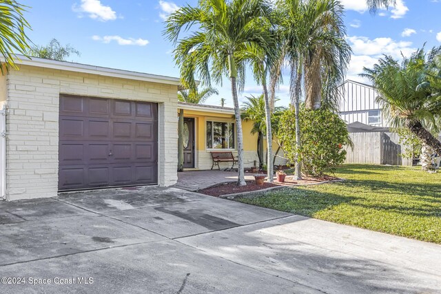 single story home featuring a front yard and a garage