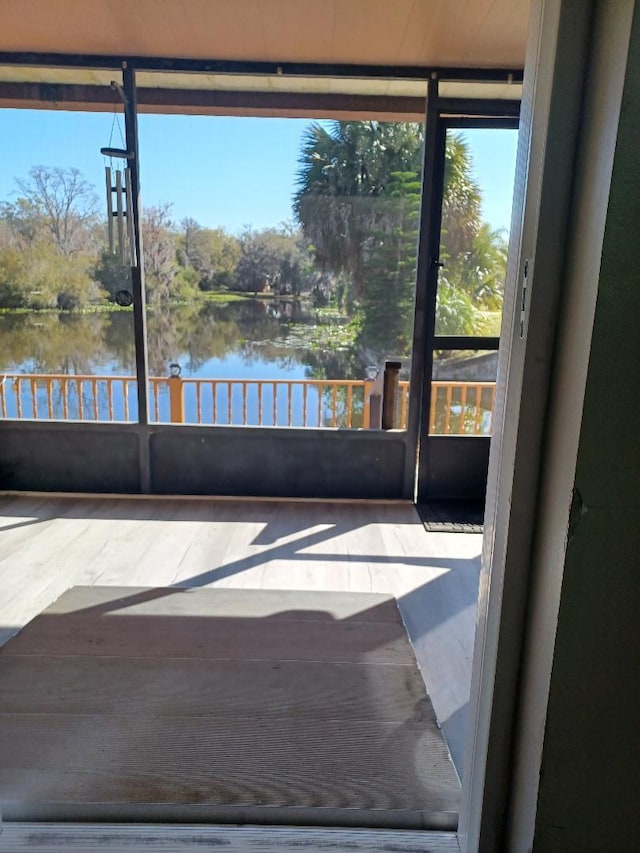 unfurnished sunroom with a water view