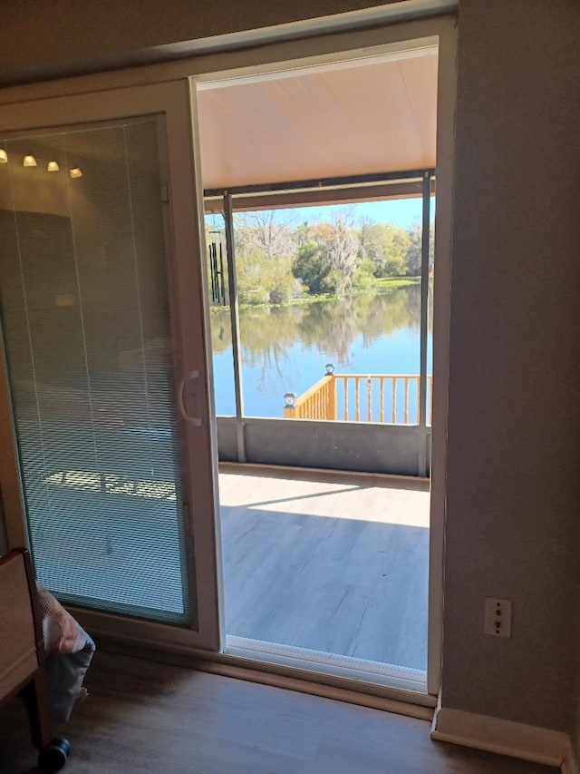 doorway to outside featuring hardwood / wood-style floors and a water view