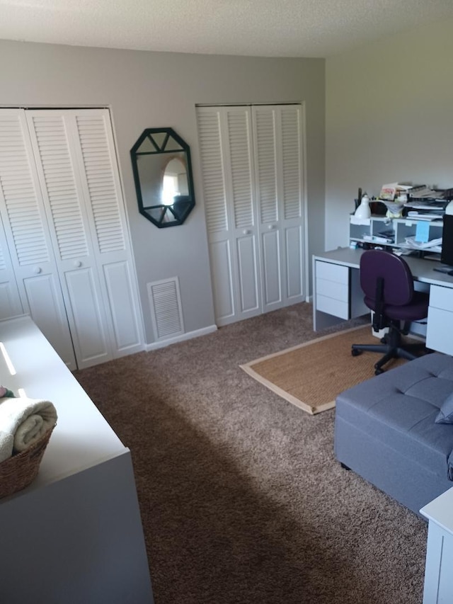 carpeted home office with a textured ceiling