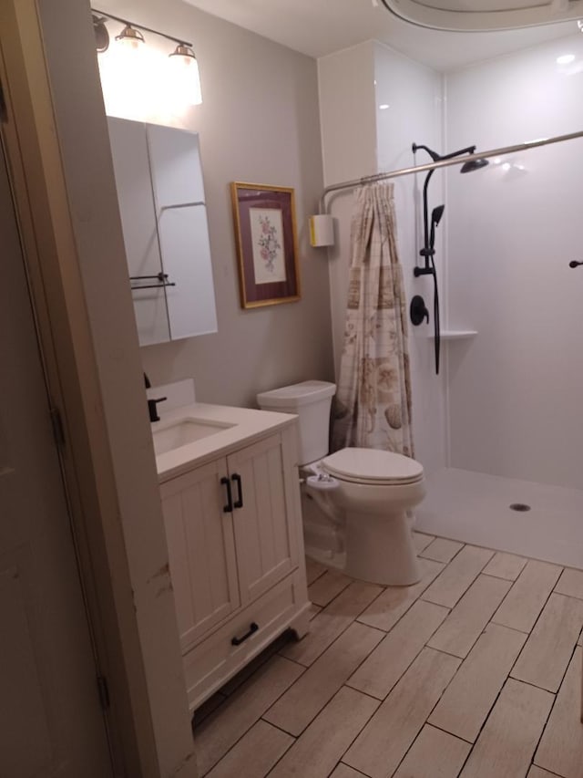 bathroom with vanity, walk in shower, and toilet