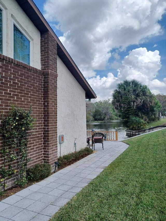 view of property exterior with a yard and a water view