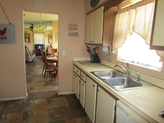 kitchen featuring ceiling fan, sink, dishwasher, cream cabinets, and decorative light fixtures