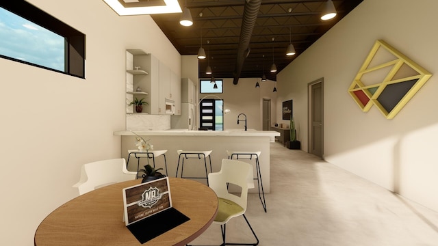 dining room featuring sink and a high ceiling