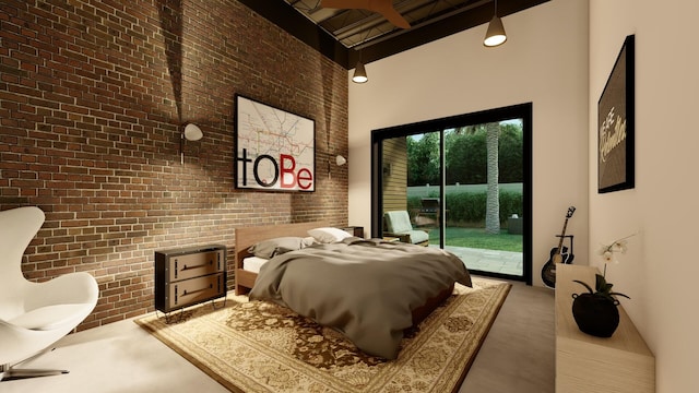 bedroom featuring concrete flooring, brick wall, access to exterior, and a high ceiling