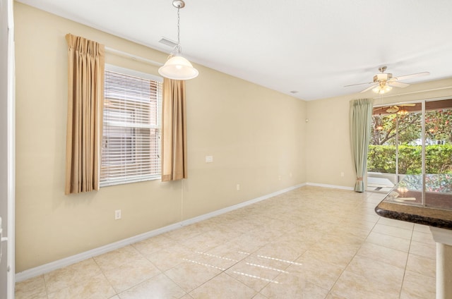 spare room with light tile flooring and ceiling fan